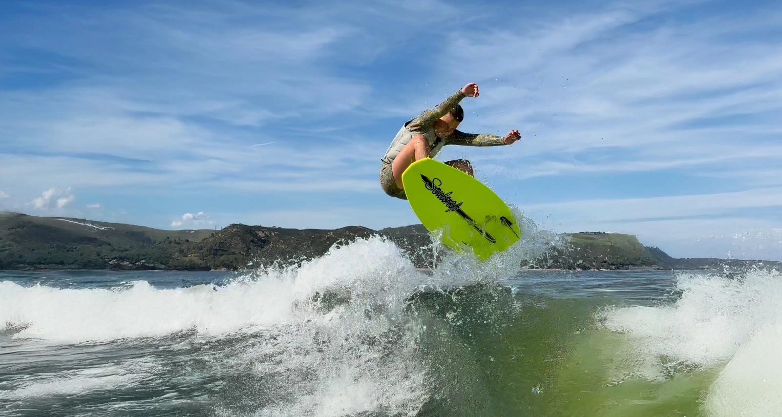 Brynlee riding wave on green Soulcraft wakesurf board