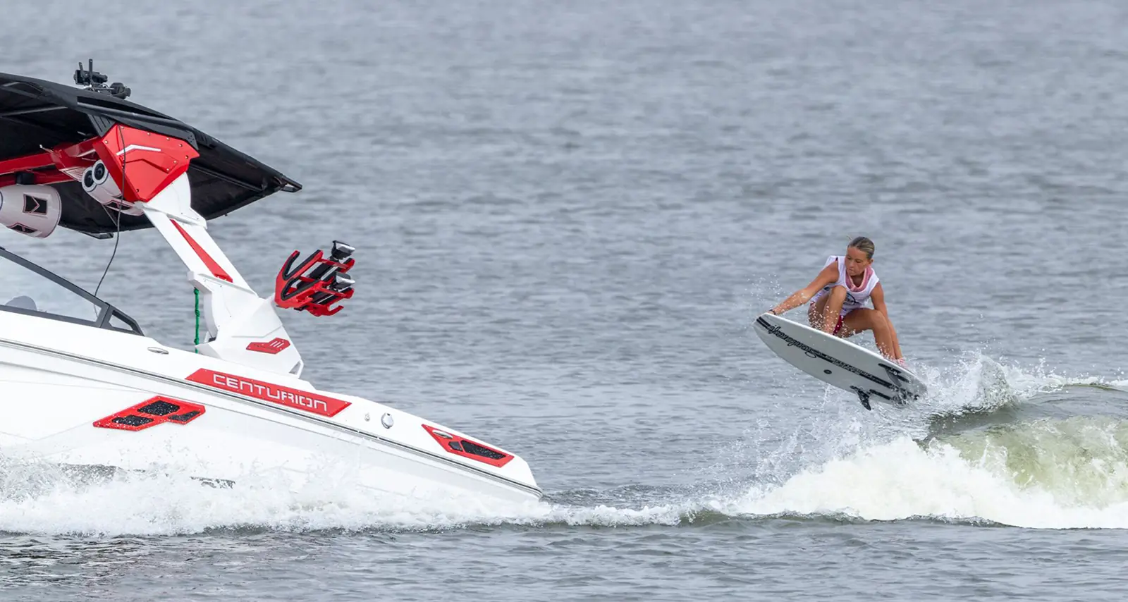 Bostyn performing trick on her board while riding behind boat
